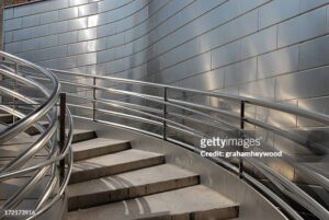 "Looking up a staircase with stainless steel, cladding and railings"